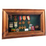 A framed group of five WWII medals with later badges etc,