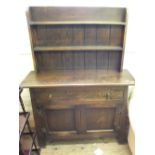 An Arts and Crafts oak shelf back dresser