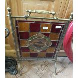 A brass framed stained glass fire screen with bird painted panel