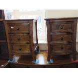 A pair of modern walnut bow front bedside chests of three drawers