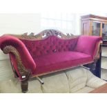 A Victorian mahogany scroll end settee with carved leaf back and maroon button back upholstery on