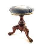 A Victorian carved Mahogany revolving piano stool with blue dralon upholstery