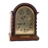 An Oak cased striking mantel clock with silvered dial and barley twist columns with 1929 East