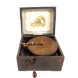 A Victorian Sonopol polyphon disc player with girl and dog print to lid and single disc