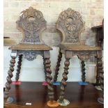 A pair of Victorian heavily carved oak hall chairs on barley twist legs