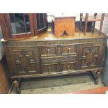 A carved oak and moulded panel front sideboard