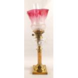 A Brass column oil lamp with cut glass bowl and etched pink shade