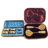 A cased pair of Silver gilt pierced spoons with figural handles plus four cased serviette rings
