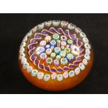 A glass paperweight by John Deacons of Scotland in a circular form with Millefiori canes split by a