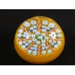 A glass paperweight by John Deacons of Scotland in a circular form with twisted tubelines and