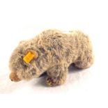 A Steiff bear with button and yellow label.