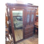 An Edwardian carved mahogany single mirror door wardrobe