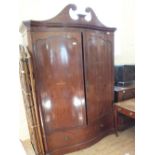 A Victorian inlaid mahogany two door Serpentine front wardrobe with swan neck pediment