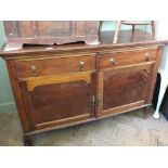 An Edwardian two drawer sideboard with two cupboards below