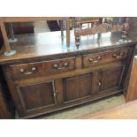 A Georgian oak sideboard with two drawers and two cupboards below