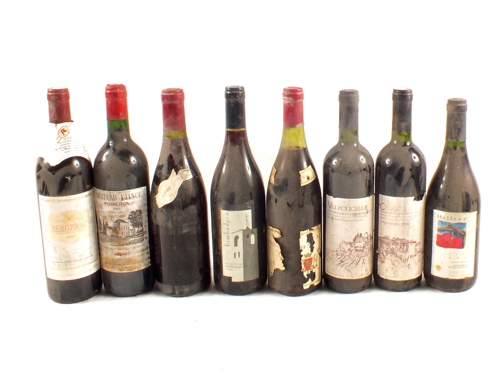 A wine rack containing various wines, Viz Chianti, Valpolicella, Bergerac 1997,