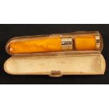 An amber and 15ct gold mounted Sampson Mordan & Co cheroot holder housed in a 9ct gold Sampson