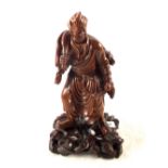 A Chinese hardwood carving of a man carrying a dog