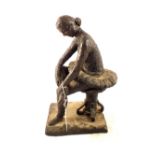 A pottery figure of a seated ballerina,