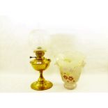 A brass oil lamp with etched globe plus two glass shades