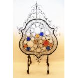 A decorative wrought iron and coloured glass fire screen (as found)