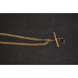 A 9ct gold necklace hung with yellow metal t-bar and garnet drop