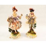 A pair of 19th Century continental porcelain figurines, man with bird and lady with flowers,