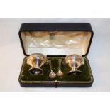 A cased Celtic style two piece silver cruet plus non matching plated spoons, Birmingham 1913,