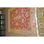 A machine made red and cream floral part silk carpet,