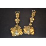 A pair of 18th Century seamed brass candlesticks with knopped stems and petal shaped bases,