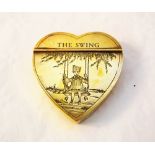 A brass heart shaped snuff box engraved with child on a swing and titled 'The Swing'