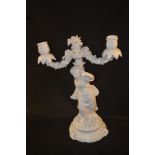 A pair of 19th Century Meissen white glazed figural and floral two branch candelabra,