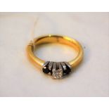 An 18ct gold diamond and black stone set ring,