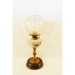 A brass column oil lamp with floral opal glass bowl and etched globe