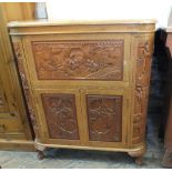 A hardwood rising top drinks cabinet with Cantonese style figural and landscape inset carving and