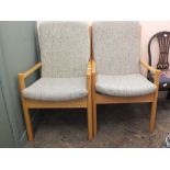 A pair of light Ercol beech armchairs in beige upholstery