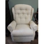 A cream upholstered electric reclining armchair