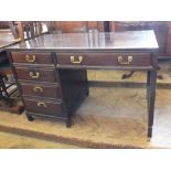 A mahogany stained five drawer single pedestal desk in an Oriental style