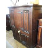 A carved oak fall front cupboard