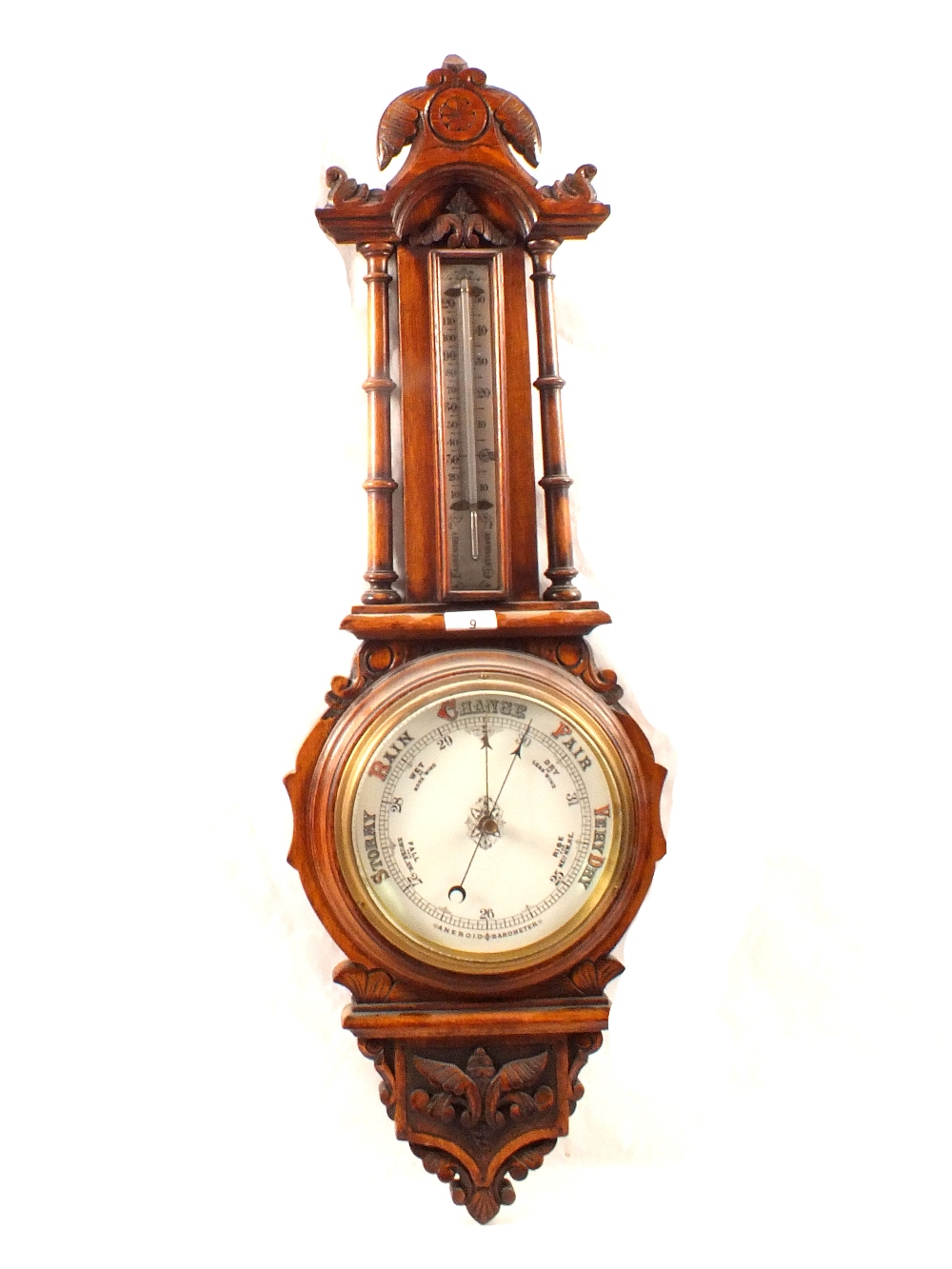 An aneroid barometer in carved oak case