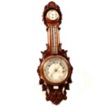 An aneroid barometer with clock in leaf carved oak case (cracked glass)