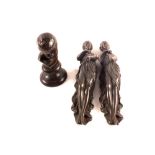 A small bronze bust of a contented child and two bronze fittings of scantily clad women,