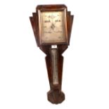 An aneroid barometer in Art Deco carved oak case