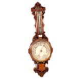 An aneroid barometer in carved oak case (name rubbed)