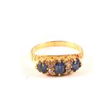 An 18ct gold three stone sapphire ring interspaced with small diamonds,