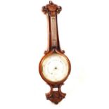 An aneroid barometer in shell and shield carved oak case, signed J.