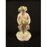 A late 18th Century Derby porcelain figure of a putto holding a basket of flowers