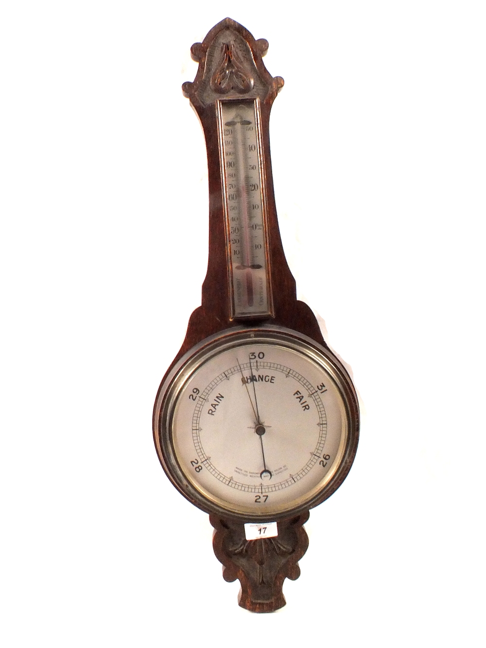 An aneroid barometer in carved oak case