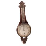 An aneroid barometer in carved oak case