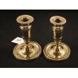 A pair of early 19th Century French brass and copper candlesticks with circles of fluted and chased